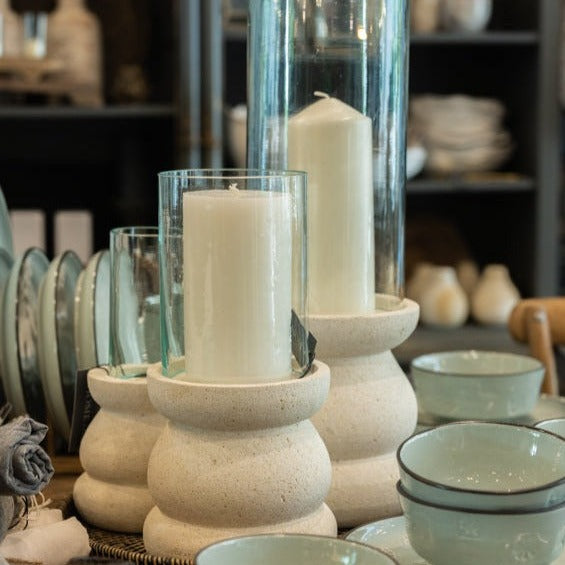 The Handcrafted Whitestone Candle Holder is expertly made from prime whitestone, complete with a recycled glass cylinder lantern. Its elegant curves complement the tall pillar candles that grace its one-of-a-kind design, creating a beautiful display.