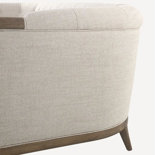 Close-up of a beige upholstered chair with wooden armrests on a white background