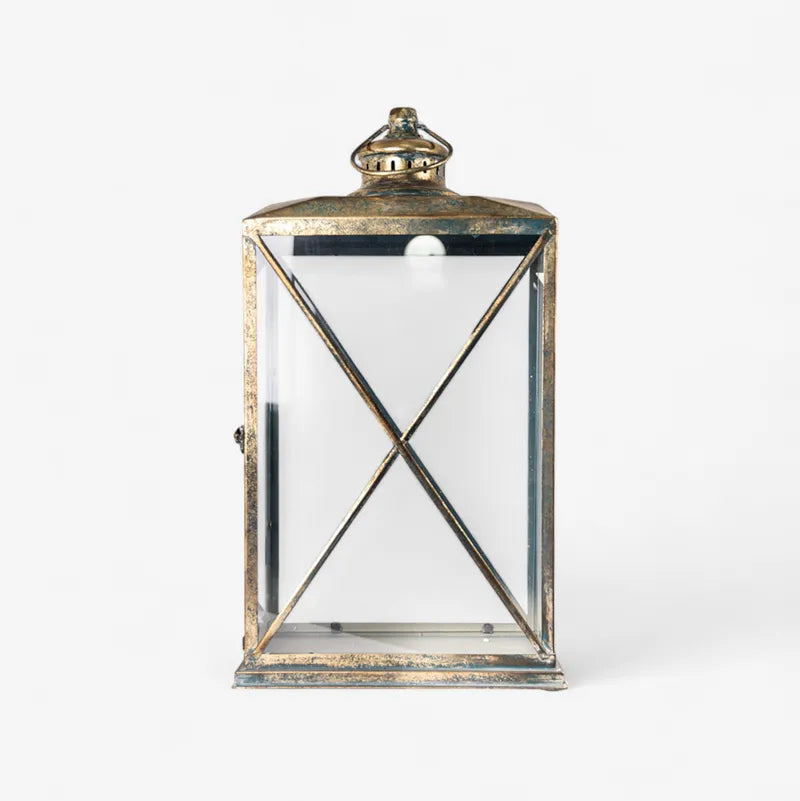 The Calypso Lanterns feature a graceful shape and an aged gold finish that add a cosy, sophisticated touch to any space. It's curved, open structure beautifully diffuses soft ambient light while enhancing your décor with elegance and height. Perfect for layering light indoors or outdoors, these lanterns look stunning on console tables, verandahs, or dining areas, creating a warm and inviting atmosphere.