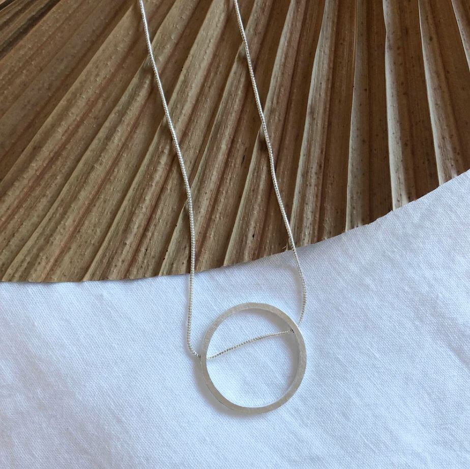 Necklace with a circular pendant on a wooden surface