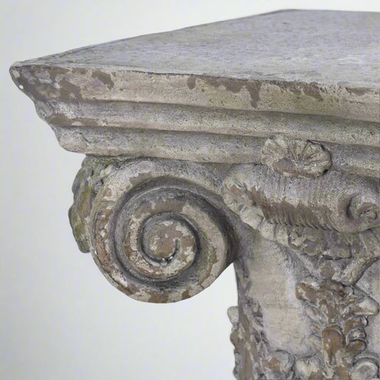 Decorative stone pedestal with intricate carvings on a white background