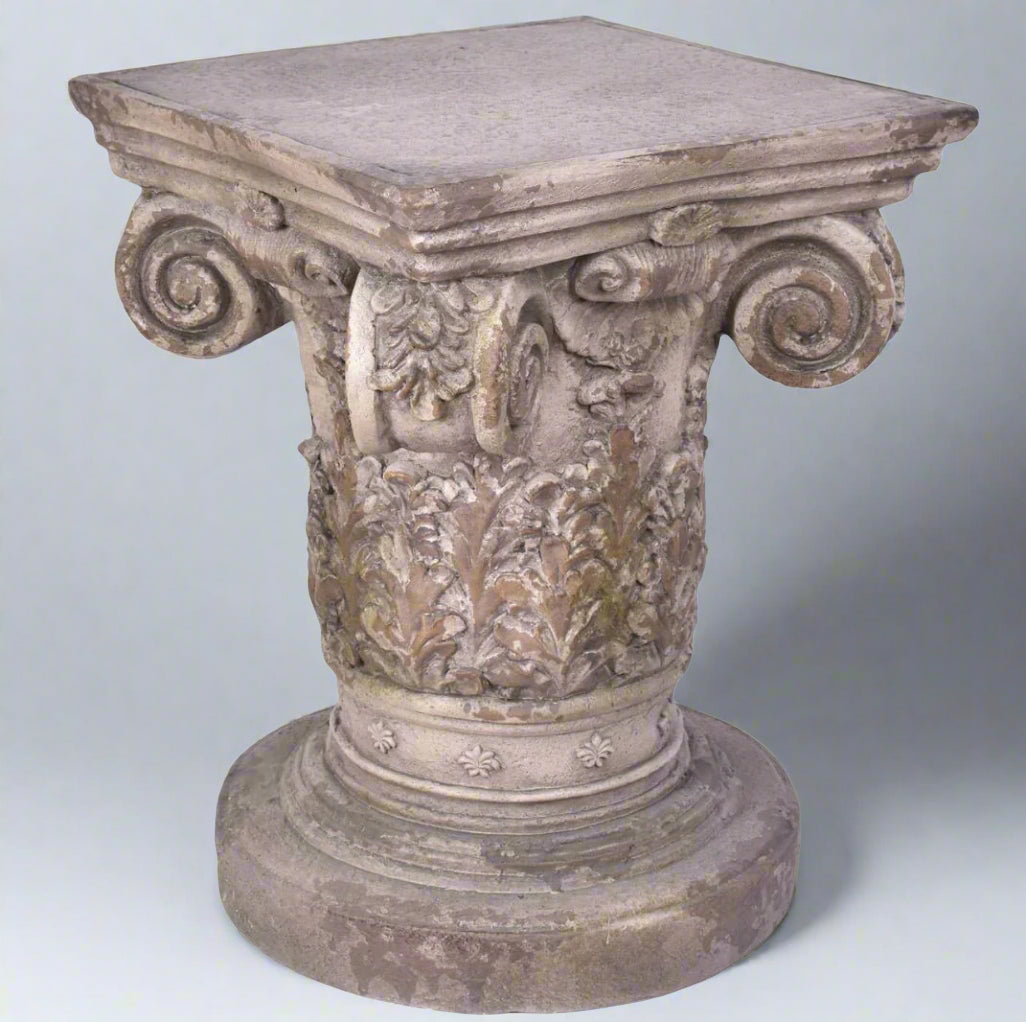 Decorative stone pedestal with intricate carvings on a light gray background