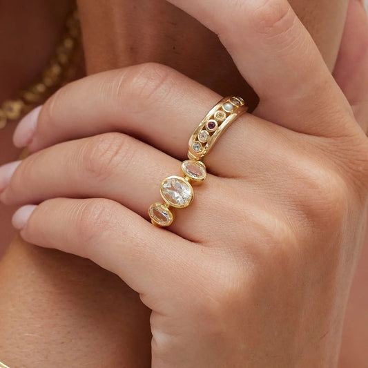Gold ring with gemstones on a hand