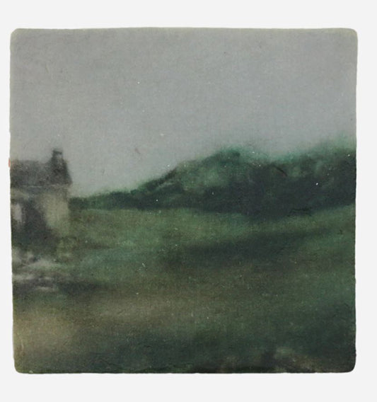 Small square tile with a landscape of a house and green fields on a gray background