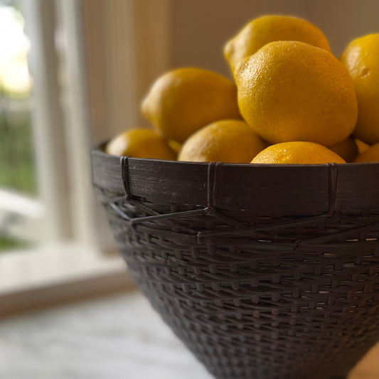 Our Banyu Handwoven Bamboo & Rattan Basket is crafted in East Indonesian Island Villages. These striking baskets can be used as an accent piece or to provide additional useful storage. Styled close up.
