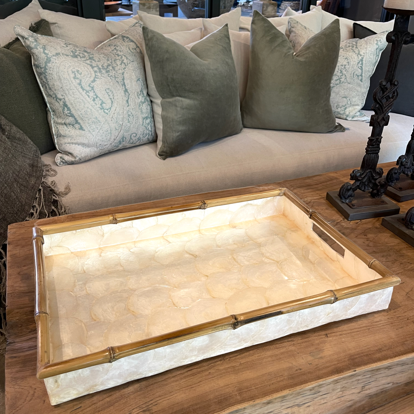 Crafted by skilled artisans in Southeast Asia, our Rectangle Capiz and Bamboo Tray adds a touch of elegance to any interior. Its sleek design and versatile size make it perfect for styling on consoles, coffee tables, or even in the bathroom. The soft tones of Capiz and the natural bamboo edge combine to create a unique and beautiful addition to any space. front