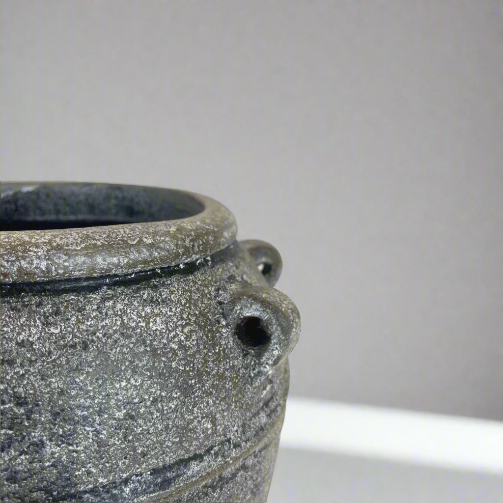 This textured vase exudes a rustic, classic charm with its traditional shape. Crafted from high-quality terracotta in South East Asia, it features a distressed and hand-painted grey and black finish. Use it as a standalone decorative piece or fill it with florals and greenery for a stunning display.