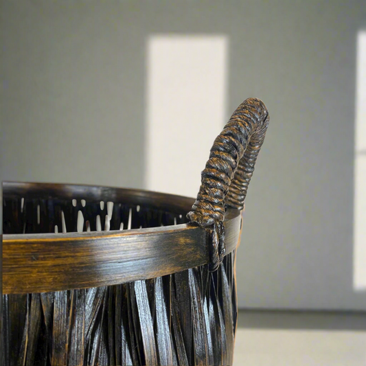 Indah Handmade Bamboo Basket is not only attractive and functional, but also deeply connected to the traditions of South East Asia Islands. With its handles and teak embellishments, this handcrafted basket embodies the rich history and skilled craftsmanship passed down through generations. Close up.