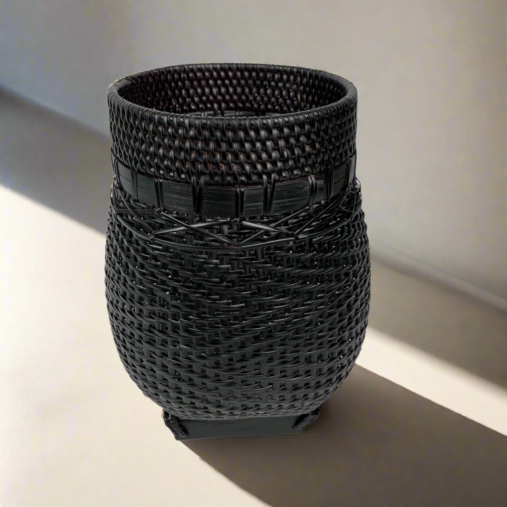 Handcrafted in traditional East Indonesian village communities, this stunning & unique Bakti Handmade Rattan & Bamboo Basket combines the natural beauty of rattan & bamboo to add texture and charm to your living space. The deep brown and black tones of the bamboo base make it perfect for storage, displaying plants, or simply as an eye-catching accent piece. Front.