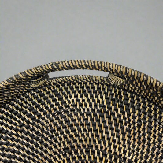 Enrich your space with the Pecatu Rattan Tray, a beautifully handwoven piece that adds texture and style to any coffee table or ottoman. Its functional handles allow for easy transport when entertaining. Top close-up