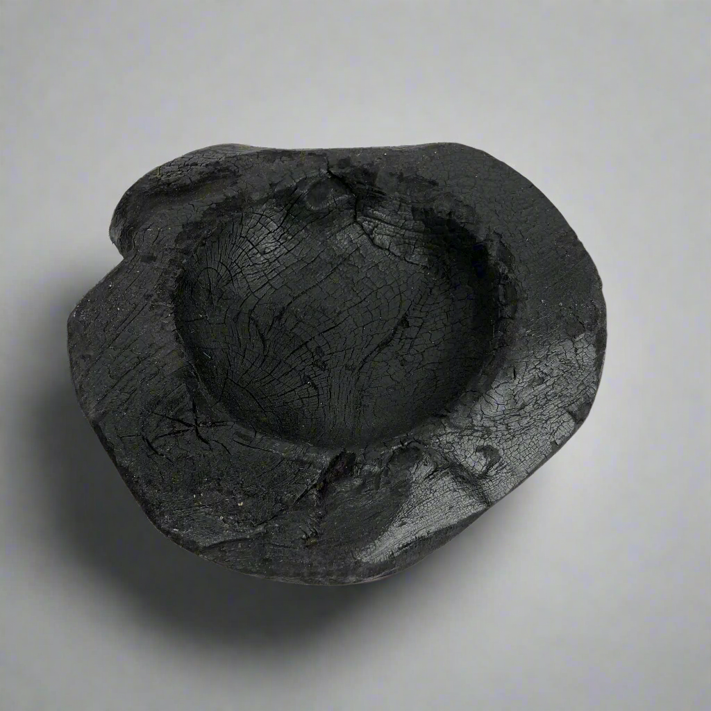 Indulge in the perfect combination of organic and airy design with our exquisite Handcarved Api Teak Burned Bowl. Crafted from the teak tree's root and expertly finished with a unique burning method, resulting in a striking deep black hue. Top.