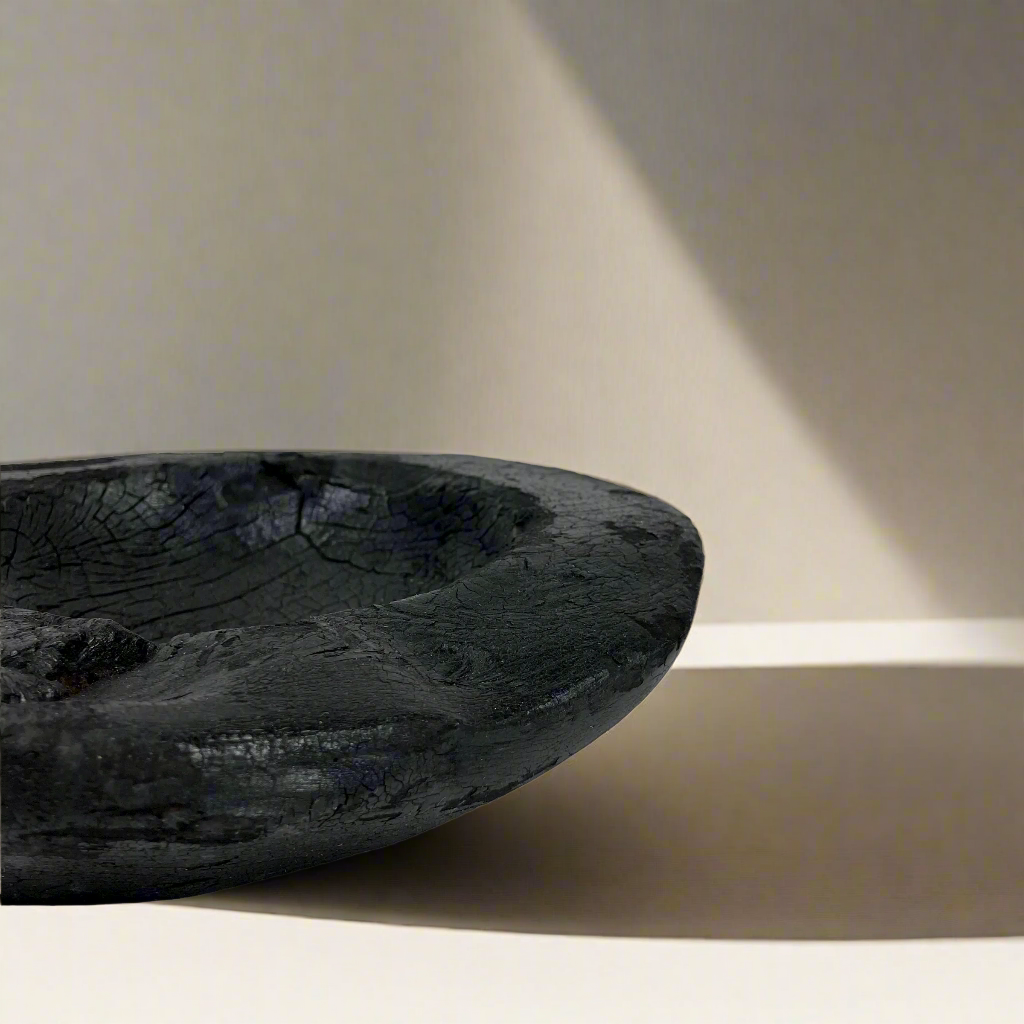 Indulge in the perfect combination of organic and airy design with our exquisite Handcarved Api Teak Burned Bowl. Crafted from the teak tree's root and expertly finished with a unique burning method, resulting in a striking deep black hue. Side