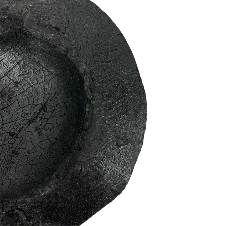 Indulge in the perfect combination of organic and airy design with our exquisite Handcarved Api Teak Burned Bowl. Crafted from the teak tree's root and expertly finished with a unique burning method, resulting in a striking deep black hue. Detail.