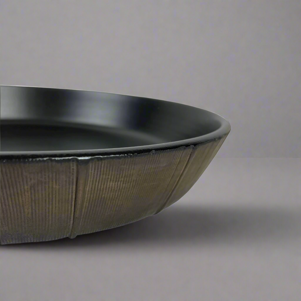 The Positano Bronze Serving Bowl boasts elegant rich tones & a versatile shape perfect for adorning your everyday table with timeless style. Detail.