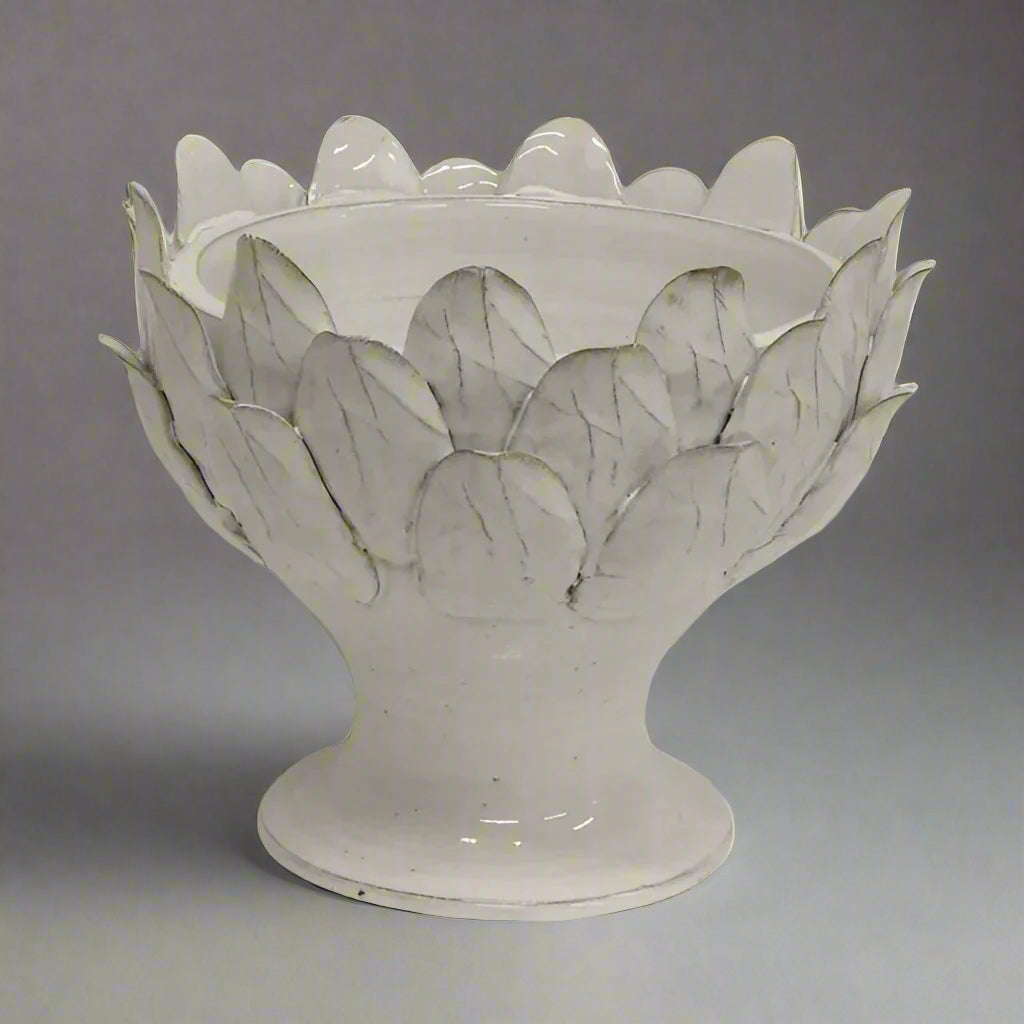 Handcrafted from terracotta and finished with an off-white glaze, this elegant Artichoke Leaf Bowl is the perfect addition to any dining or coffee table, or even a console. Its versatile design makes it equally suitable as a decorative object or a functional serving vessel.