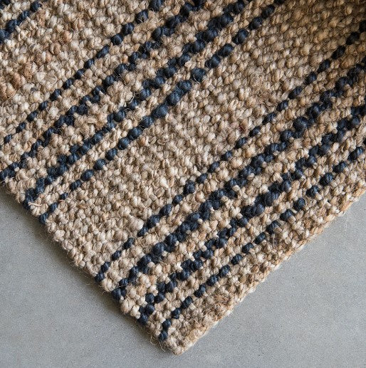 The hand-crafted Smith Stripe Jute Mat offers an elegant vintage look and feel through the combination of natural and graphite colours in a boucle weave. An environmentally friendly and sustainable jute fibre, it adds a tasteful layer of texture and style to any space, with minor irregularities that make it unique.