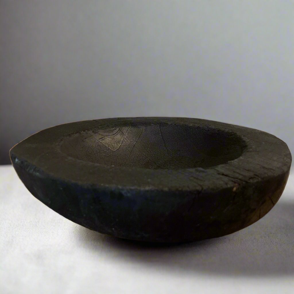 Indulge in the perfect combination of organic and airy design with our exquisite Handcarved Api Teak Burned Bowl. Crafted from the teak tree's root and expertly finished with a unique burning method, resulting in a striking deep black hue.