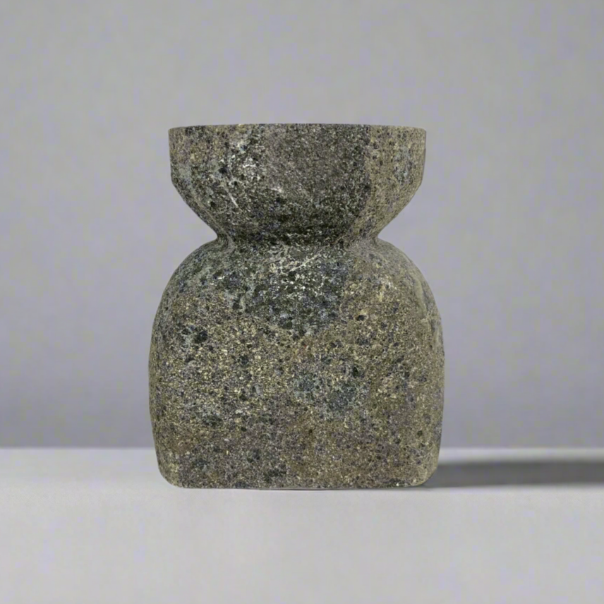 Experience the captivating soft glow of the Bari Black Laval Stone Candle Holder, the perfect balance of strength and grace. Illuminate any space with this elegant yet sturdy piece, creating a tranquil atmosphere that soothes the senses. Front.