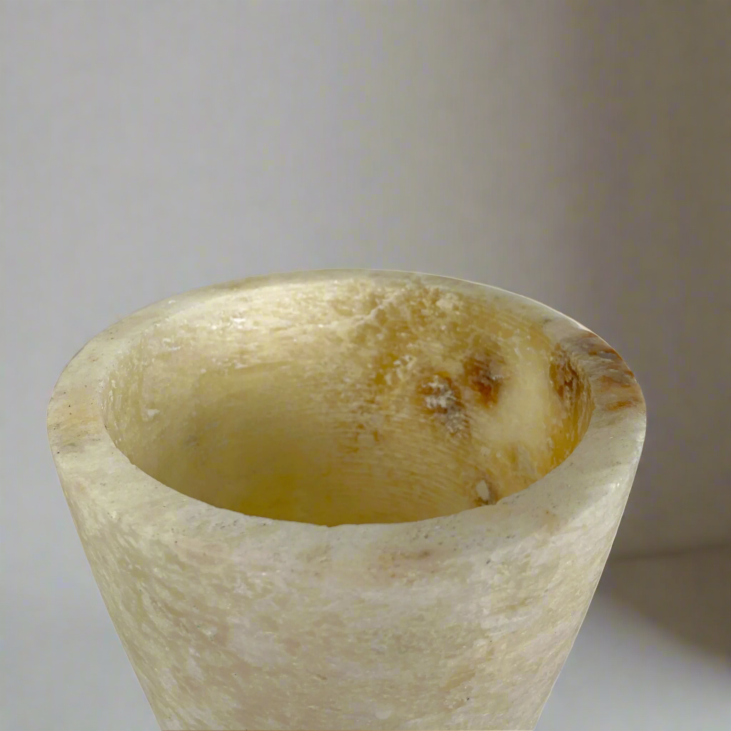 Elevate your space with the artistry of this hand-carved, smooth-textured Onyx Vase. Its unique, naturally-formed color veins and solid stone construction make a bold statement in any display. Indulge in the luxurious, gallery-quality craftsmanship of this Grand Onyx Vase.