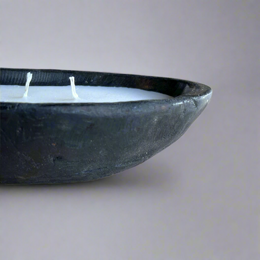 Experience the one-of-a-kind beauty of the Handcarved Baki Teak Candle, crafted from the natural root of a teak tree and filled with the highest quality wax for an unparalleled lighting experience. Front.