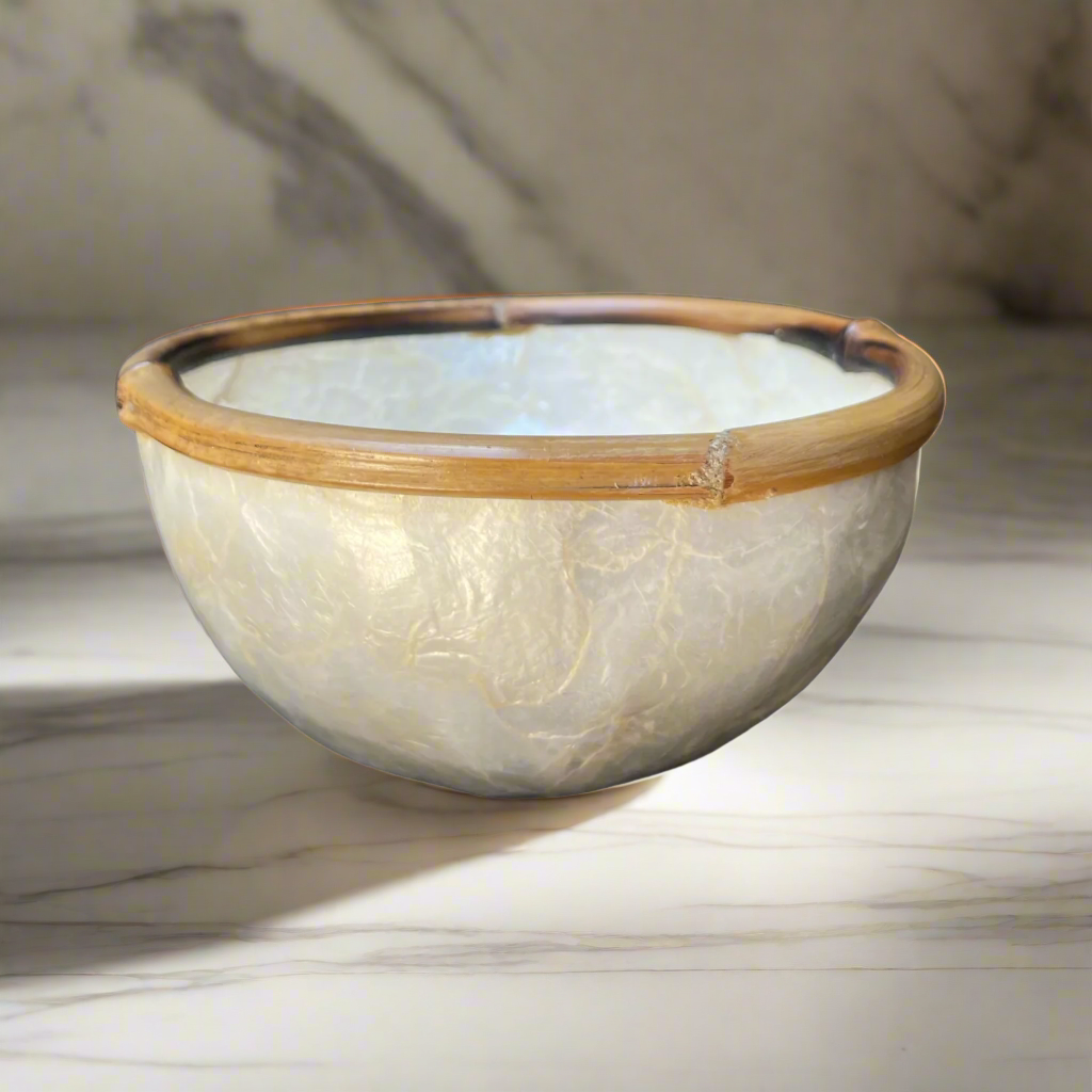 Experience the captivating beauty of our Capiz & Bamboo Bowl from Southeast Asia, featuring a charming design with a bamboo rim. Elevate any space with its versatile functionality as a decorative piece, trinket holder, or food serving dish. Side