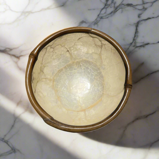 Experience the captivating beauty of our Capiz & Bamboo Bowl from Southeast Asia, featuring a charming design with a bamboo rim. Elevate any space with its versatile functionality as a decorative piece, trinket holder, or food serving dish.