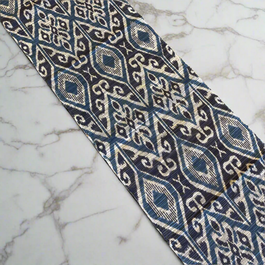 This eye-catching Blue Hand-Printed Roro Water Hyacinth Table Runner provides an exquisite design with intricate black and teal patterns adorning the organic base. It is an ideal way to instantly upgrade any table decor and brings a touch of traditional Batik printing seen in East Indonesian villages.