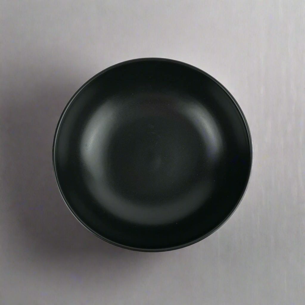 Experience the simplistic elegance of our Handcrafted Black Jenis Bowl, designed with a smooth and gentle edge for a touch of refinement. Top.