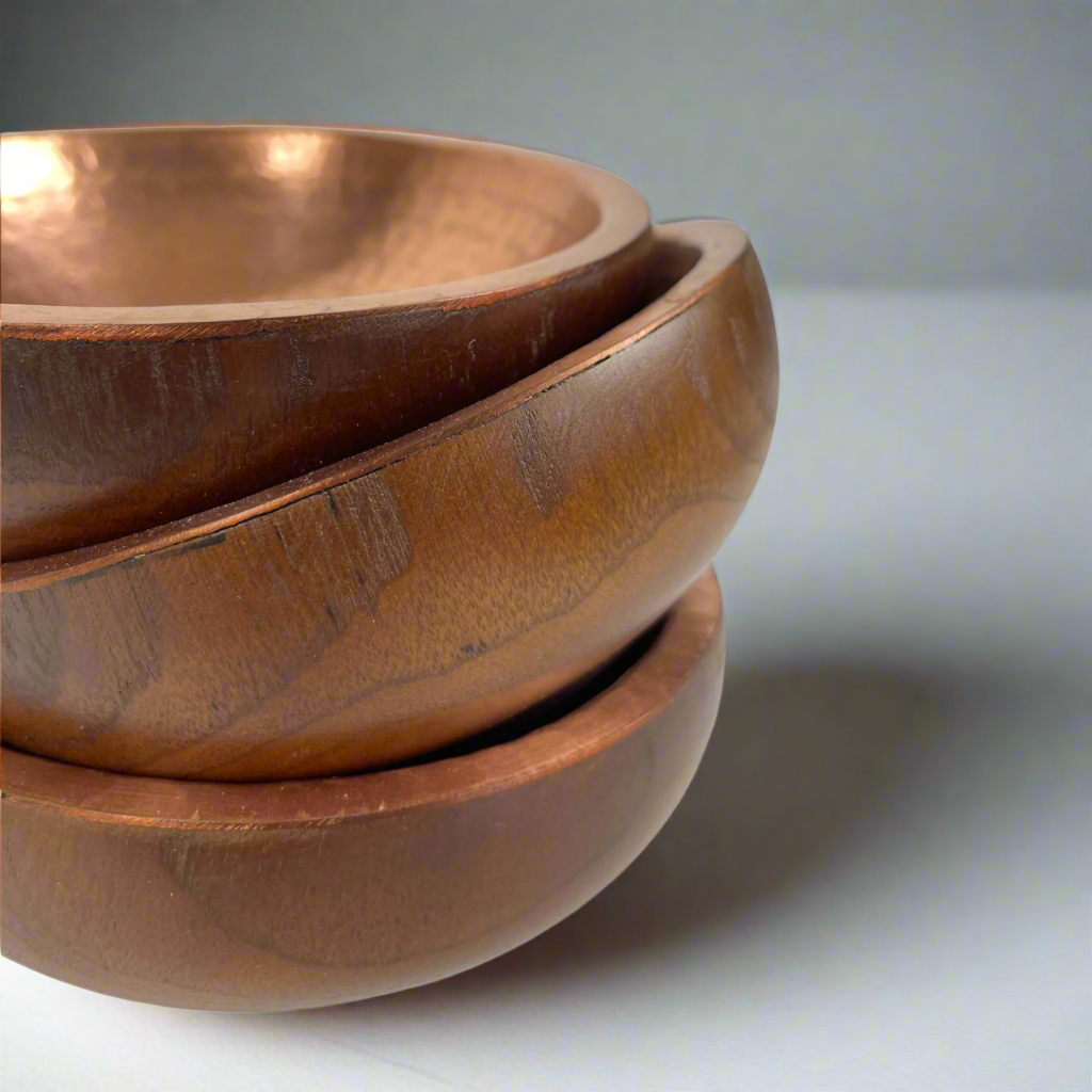 Capture attention with Ailan Teak Wood Copper Bowls. The combination of teak and copper creates a stunning texture and dimension for any space. A remarkable decorative addition in any room.