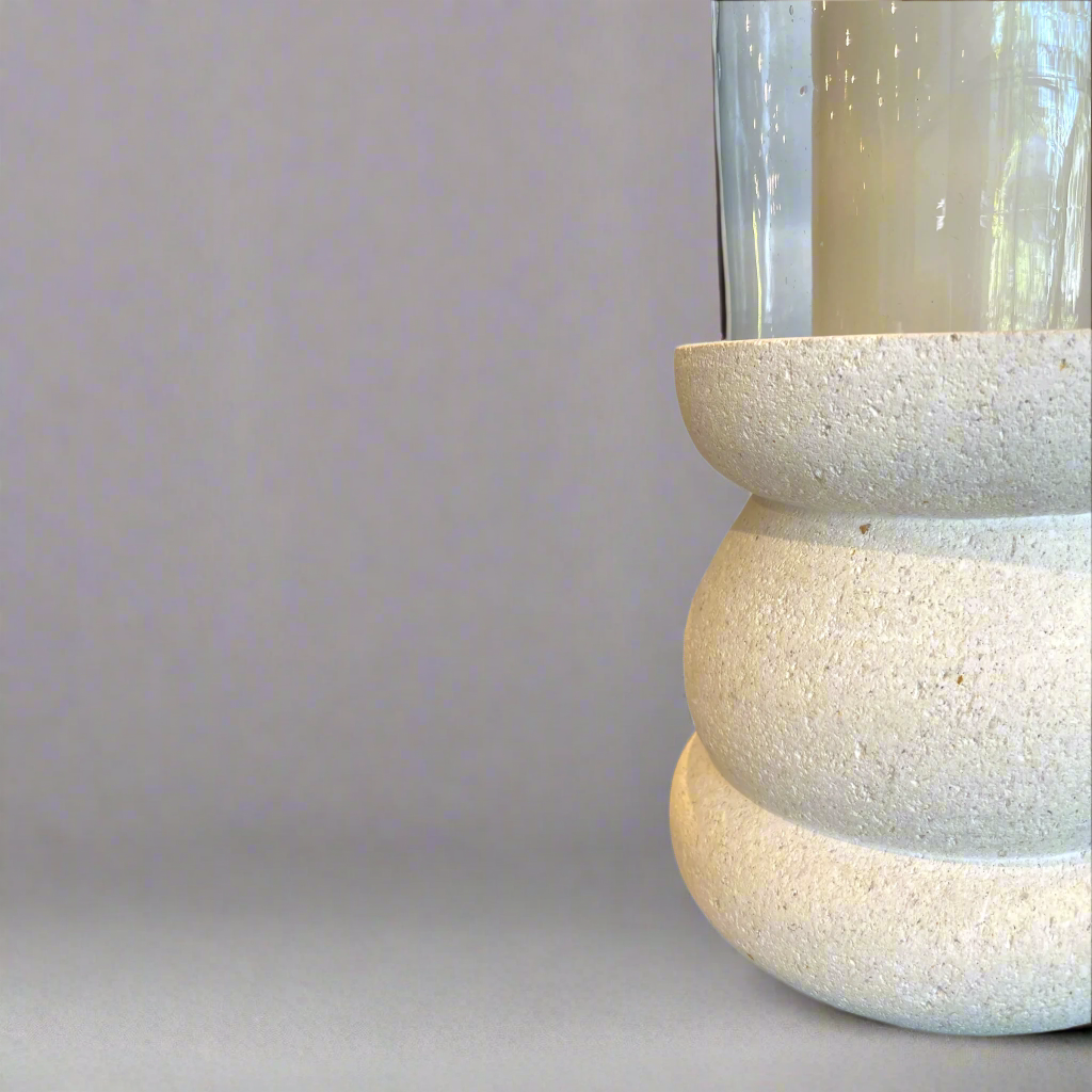 The Handcrafted Whitestone Candle Holder is expertly made from prime whitestone, complete with a recycled glass cylinder lantern. Its elegant curves complement the tall pillar candles that grace its one-of-a-kind design, creating a beautiful display. Detail.