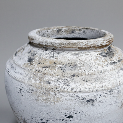 Weathered ceramic jar on a gray background