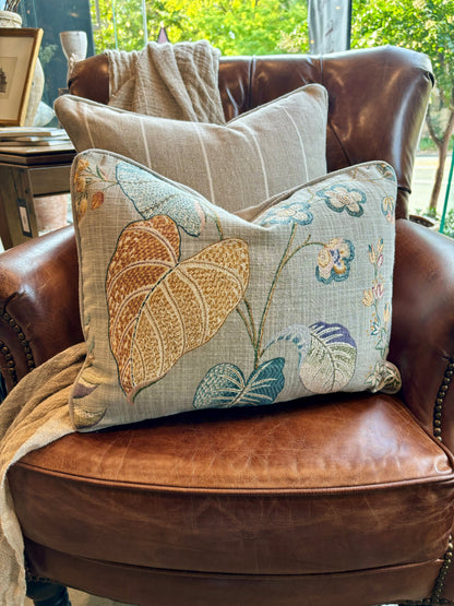 Indulge in the exquisite artistry of the Claudette Floral Linen Lumbar Cushion. Crafted from a sturdy linen blend, it showcases a stunning floral pattern in vibrant hues against a subtle taupe background, with a reverse side of elegant neutral fabric. A feather insert adds an extra touch of comfort.