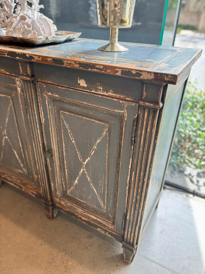 Meticulously crafted from reclaimed timber and adorned with a distressed blue paint finish, this one-of-a-kind sideboard adds versatility to any space. Whether in a dining room, bedroom, or elegant hallway, its three doors offer ample storage. Corner