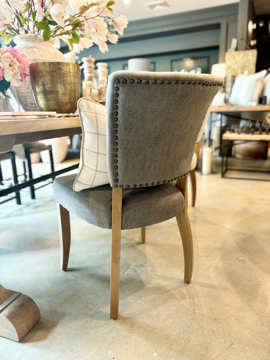 The Chelsea Dining Chair is constructed with a grey linen finish and features stud detailing on the back for a sophisticated, yet comfortable aesthetic. Back