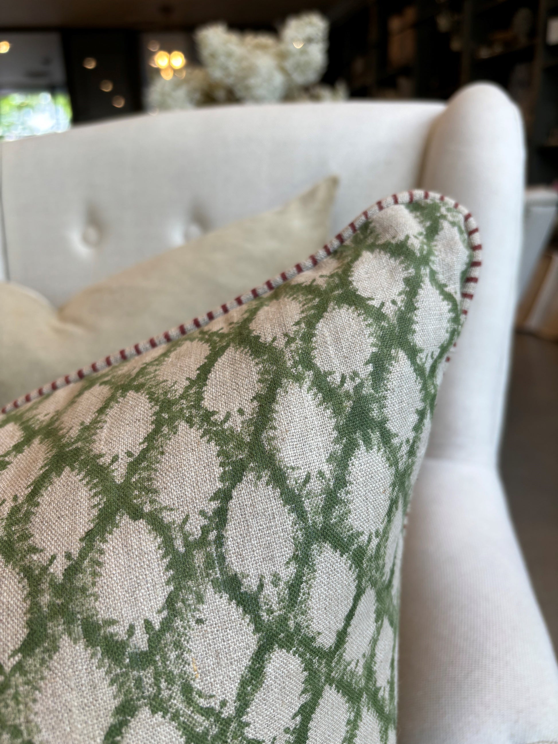 Elevate your home decor with the Cypress Block Printed Linen Green Cushion from CHAMOIS, a beloved Swedish brand known for their impeccable style. Crafted from premium Belgian 100% linen and featuring a soft feather insert, this cushion is a must-have for those who appreciate luxurious and high-quality design. Corner close up.