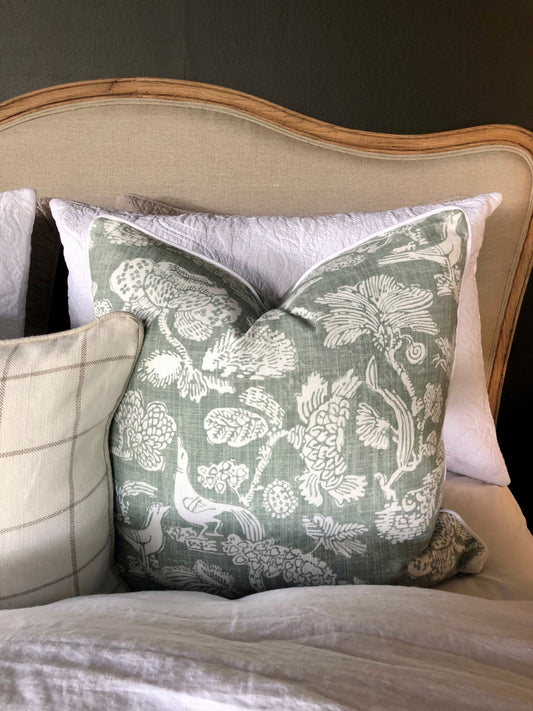This elegant Richloom Platinum Howland Linen Moss Green Cushion is crafted from Richloom's global fabric house, featuring a graceful white pattern of trees and birds on a pale green background. Its sumptuous heavyweight fabric and the luxurious feather insert make it a perfect accent for your plush home decor.