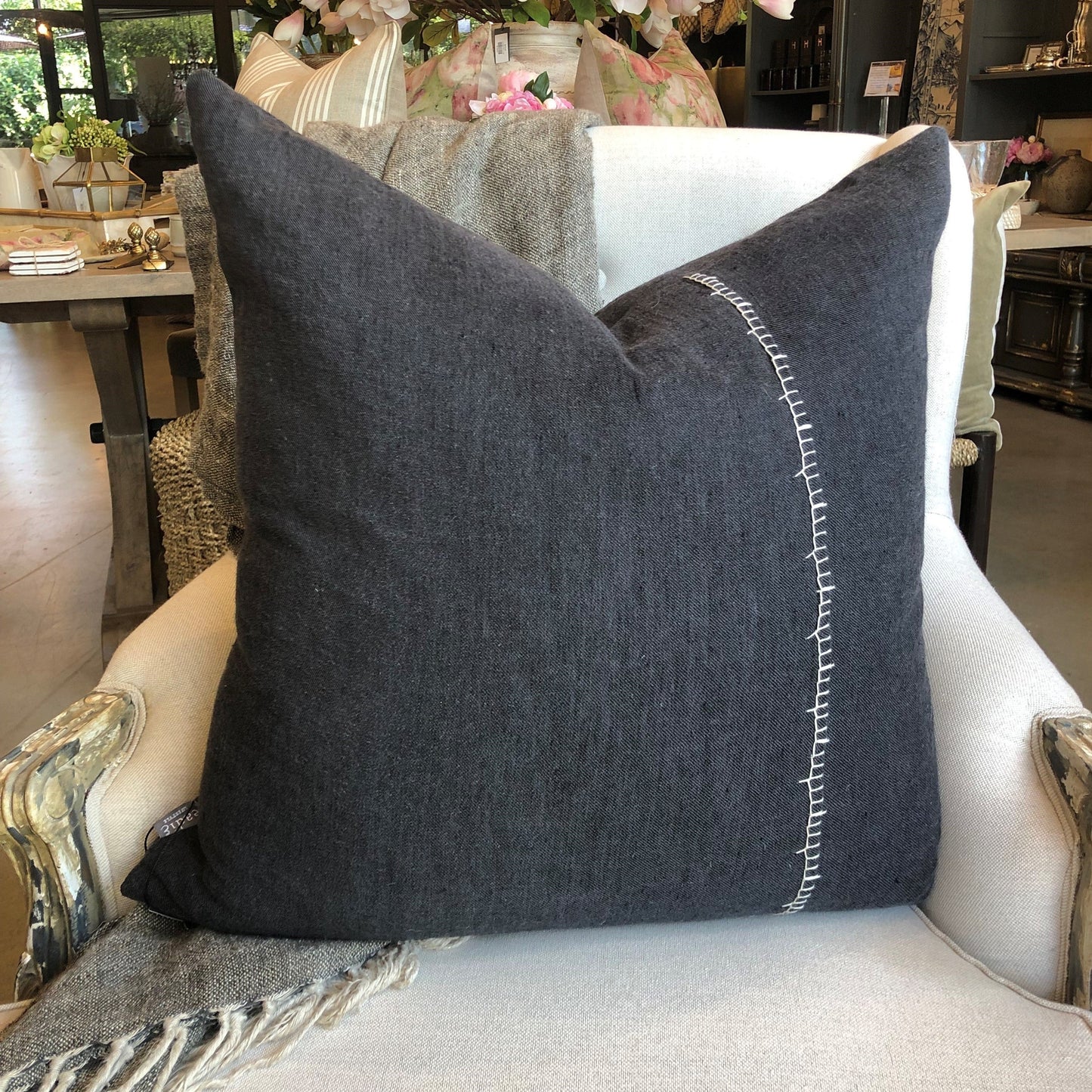 Our Amber Linen Hand-Embroidered Charcoal Cushion has been specifically crafted with meticulous detail and casual living in mind. This muted black cushion with its contrast handcrafted blanket stitch adds a stylish touch to any high-traffic area, providing both durability and comfort. Its exclusive plump feather insert guarantees the most comfortable seating experience, while its 100% linen composition ensure quality. OEKO-TEX® and GOTS certified, this cushion is a smart addition to any space.