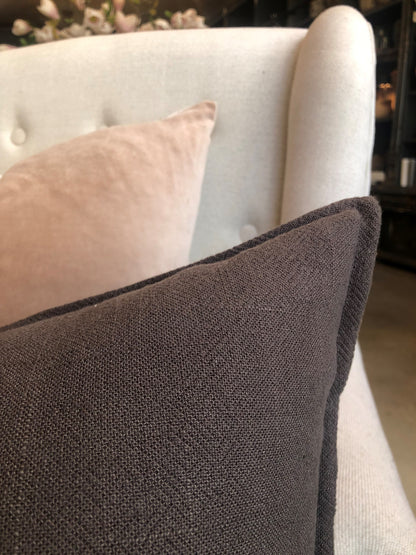 The plush feather filled Oban Herringbone Woven Stonewashed French Linen Lumbar Cushion showcases a classic herringbone pattern woven from French Linen which has been stonewashed to achieve a soft luxurious feel. Close up corner.