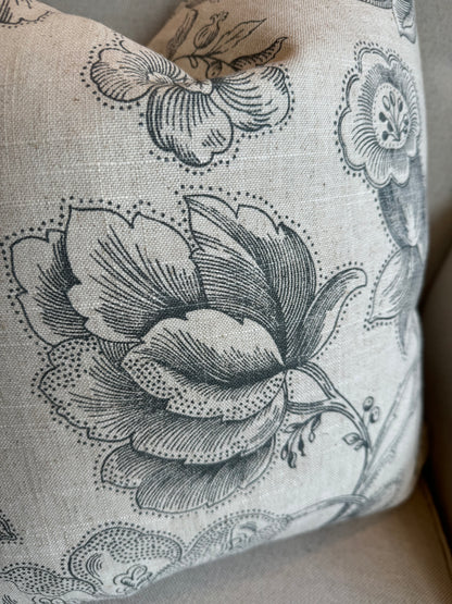 The Brielle Oatmeal and Charcoal Floral Linen Cushion boats a delightful charcoal floral pattern on a serene oatmeal backdrop. Its feather filling guarantees ultimate comfort, and the back is lined with matching oatmeal linen for a harmonious finish.