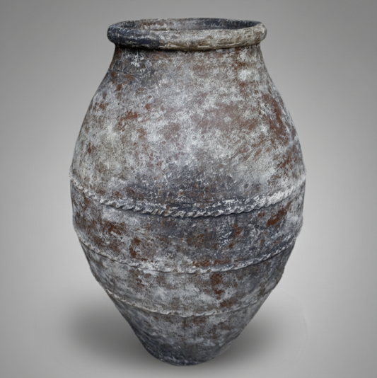 Vintage terracotta pot with a textured surface on a gray background