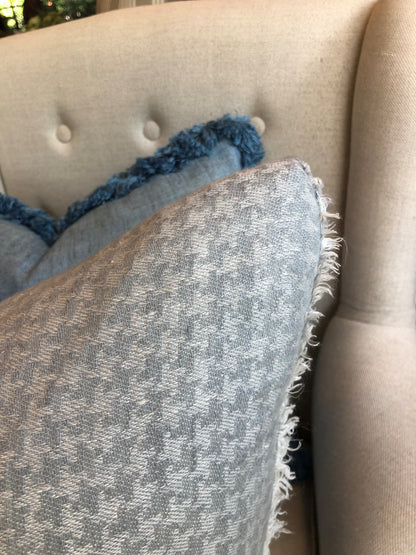 The Sophia Houndstooth Silver Grey Linen Cushion is crafted with 100% linen and features a classic silver &amp; white houndstooth pattern. This timeless cushion brings a subtle sophistication to any space with its fine white frayed edge and will instantly elevate any room. Close up corner.