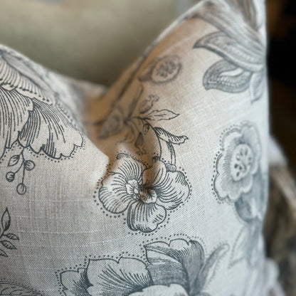 The Brielle Oatmeal and Charcoal Floral Linen Cushion boats a delightful charcoal floral pattern on a serene oatmeal backdrop. Its feather filling guarantees ultimate comfort, and the back is lined with matching oatmeal linen for a harmonious finish.