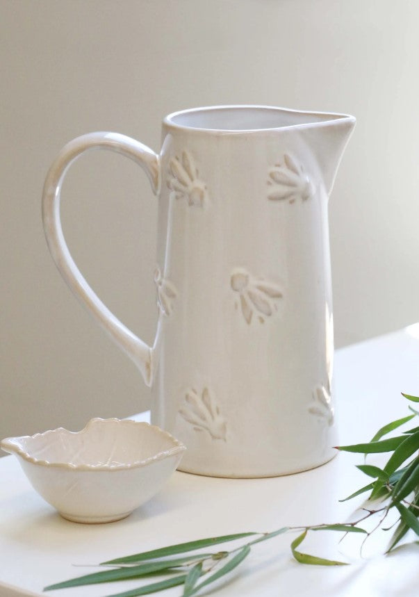 Experience the exquisite design of the Abeille Bee Cream Ceramic Jug, with an embossed bumblebee design and glossy cream-colored glaze. Perfect for holding water or displaying beautiful flowers, this jug adds a touch of elegance to any kitchen. Plus, its large, comfortable handle makes it easy to use.