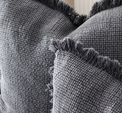 The Adele Cotton Cushion features a plush 100% cotton weave and hand frayed edging. The addition of a unique sulphur-wash finish adds a touch of sophistication to this dark grey slate design. And, for ultimate comfort, indulge in the exclusive plump feather insert included with your purchase. 60cm x 60cm. Corner close-up.