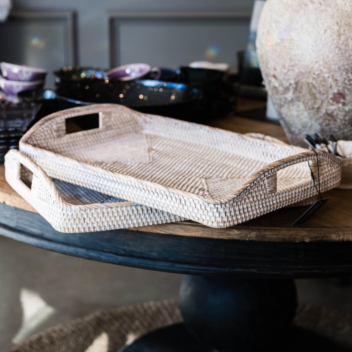 The Handmade Bulan White Washed Rattan Tray was crafted where the history of basket-weaving goes back many centuries. It has a light whitewashed finish that gives off a calm vibe and it can easily transport plates and glasses from the kitchen to the dining table, or it can be placed as decoration on a coffee table or ottoman. Styled.