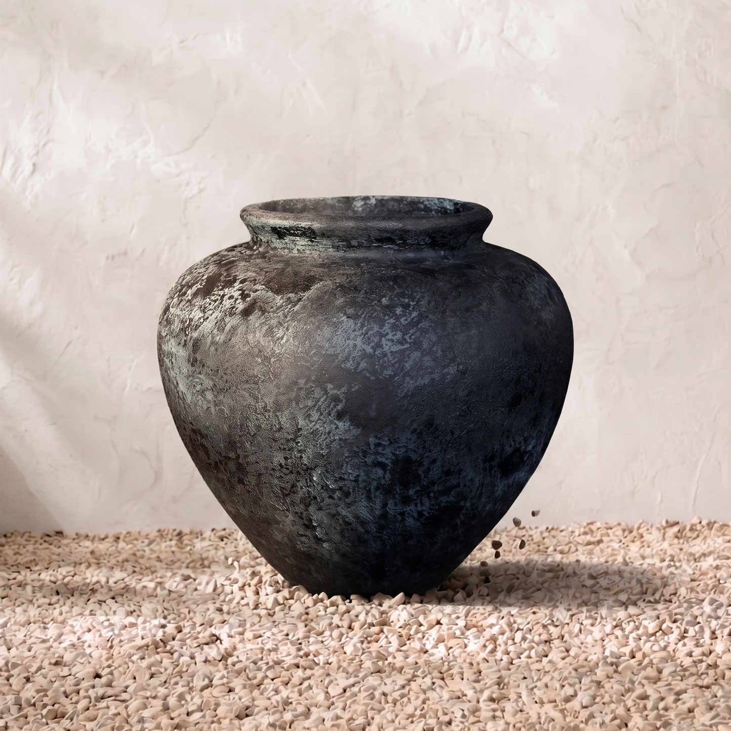 Black vase on a textured surface with a neutral background