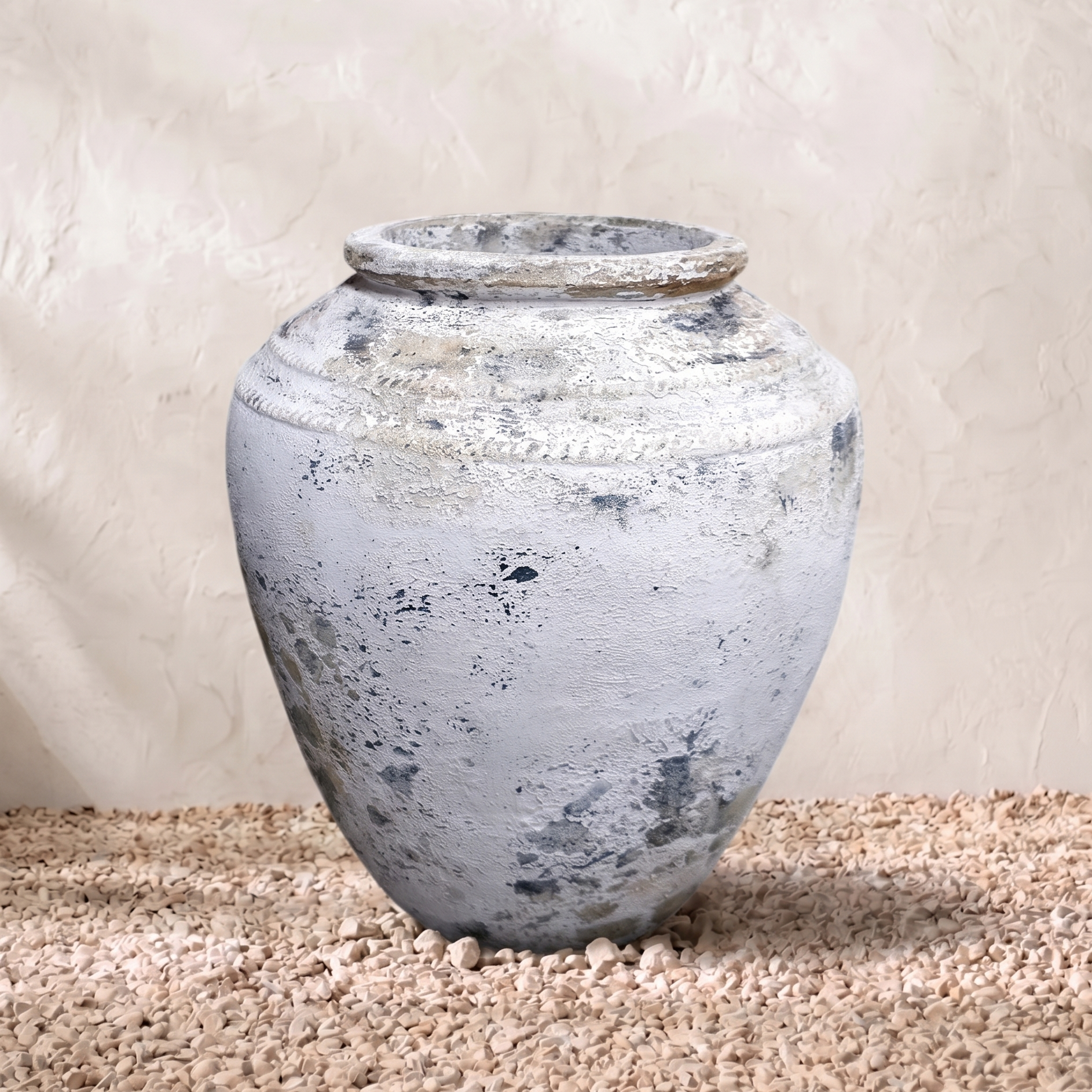 Vintage-style terracotta pot on a textured surface with a neutral background