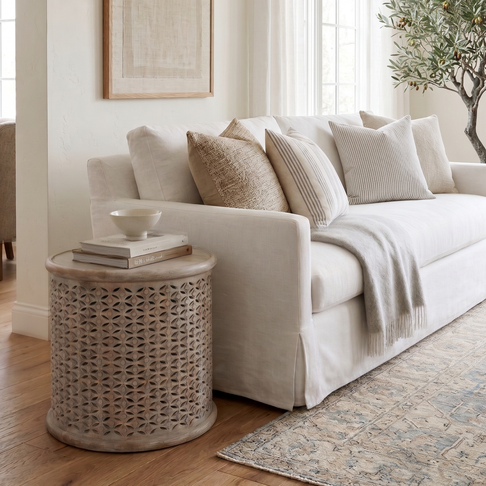 Cozy living room with a white sofa, wicker side table, and decorative elements.