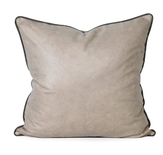 Beige pillow with black trim on a white background