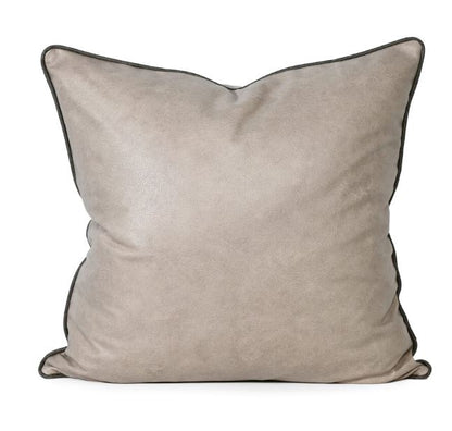 Beige pillow with black trim on a white background